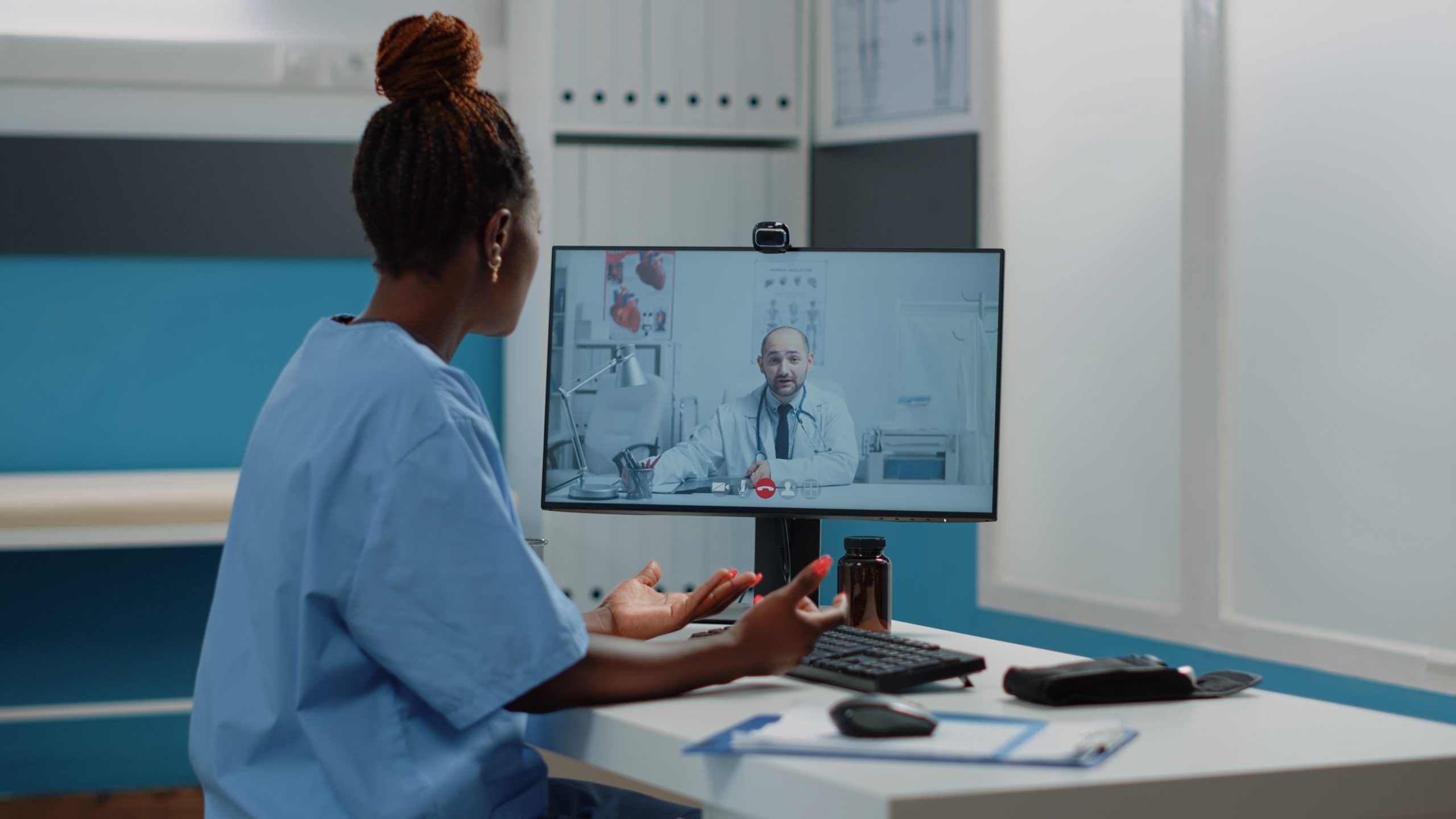 Woman nurse using computer for video call with doctor